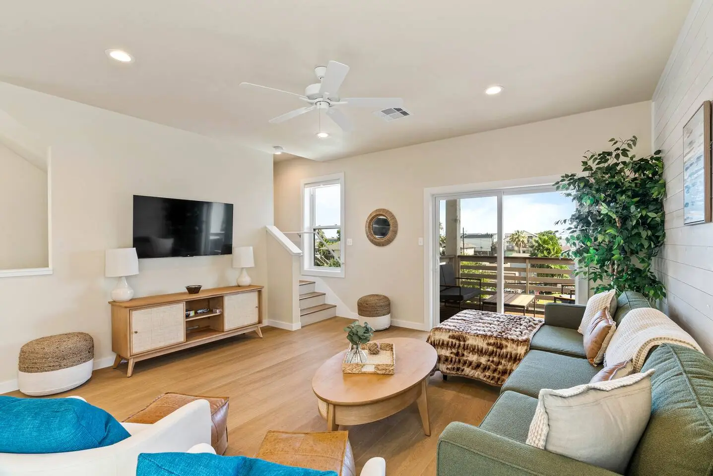 Cozy living room with a smart TV, comfy sectional, and balcony access - perfect for relaxing with games or a movie after a day in Port A.